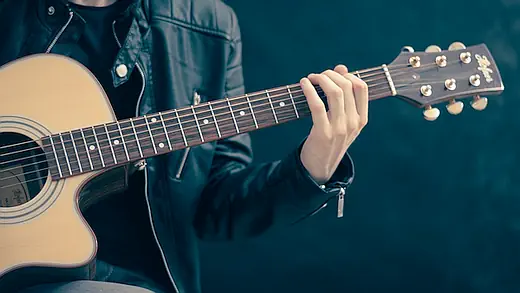 Bild einer Gitarre in der Hand des Spielers